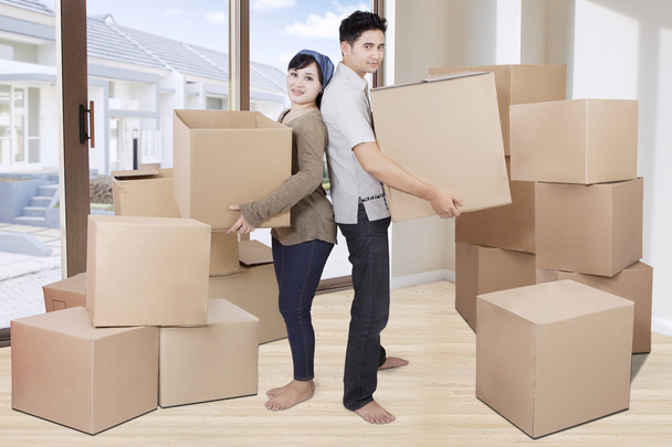 Two couple lifting cardboards at home - Foto, Imagem