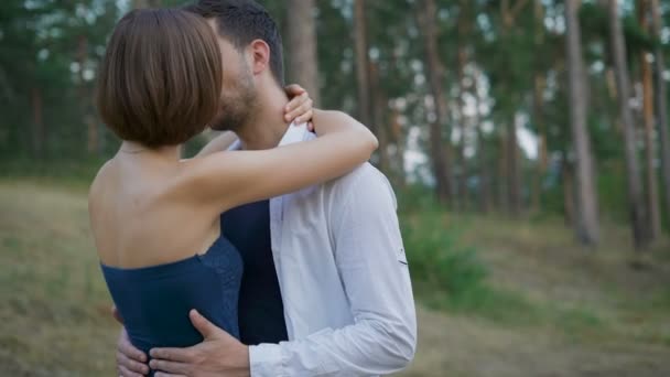Romantic couple of young people are embracing a clearing in the summer forest. - Video, Çekim