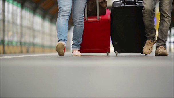 Pés andando sobre os passageiros da plataforma com uma mala, jovem casal caminhando ao longo da plataforma para o trem com bagagem
 - Filmagem, Vídeo
