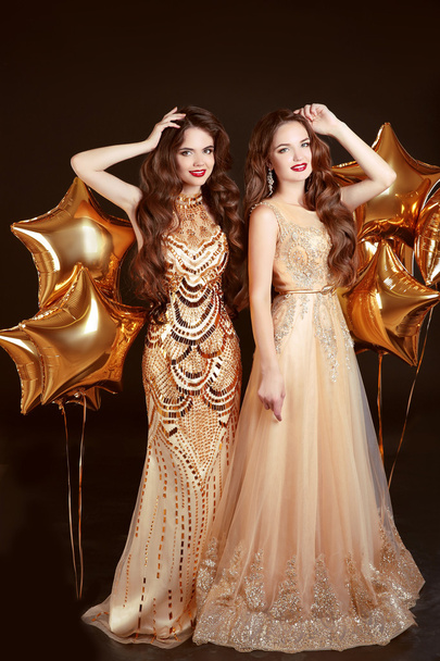 Two women in fashion dress, party celebration. Brunette twins gi - Foto, afbeelding