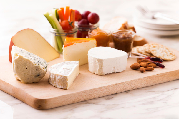 Prato de queijo com diferentes queijos e uvas
 - Foto, Imagem