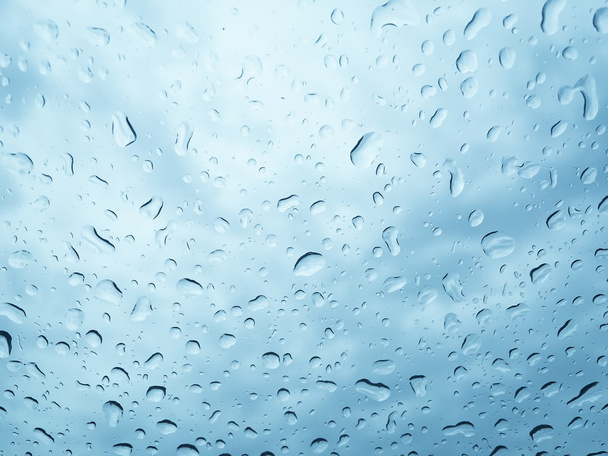 Rain drops on glass window blue sky background - Photo, Image
