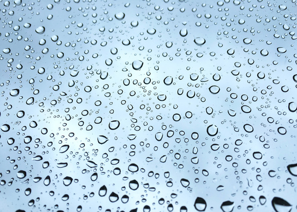 Regentropfen auf Glas Fenster blauer Himmel Hintergrund - Foto, Bild