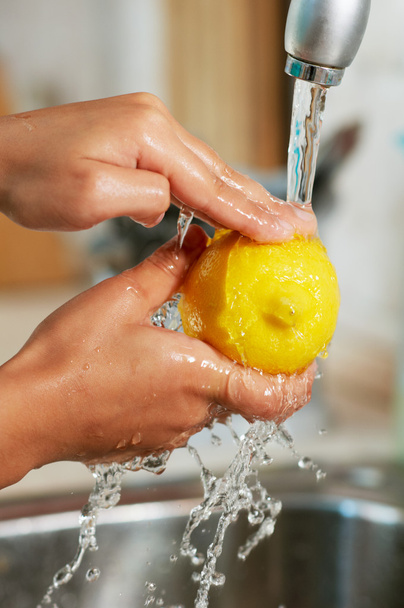 The lemon is being washed in the water - Foto, Imagen