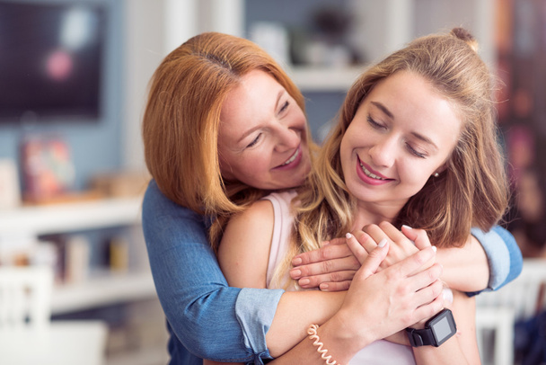 Cheerful mother and daughter embracing - Photo, Image