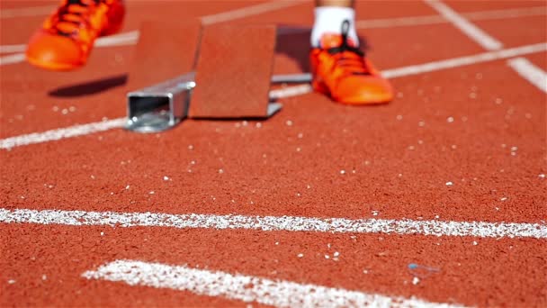 Pojedynczy lekkoatleta sprinter na stadionie, zaczynając z bloku, w zwolnionym tempie - Materiał filmowy, wideo