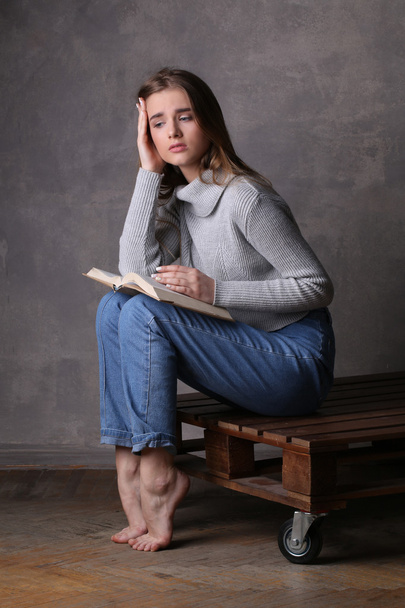 Girl with a book. Gray background - Φωτογραφία, εικόνα
