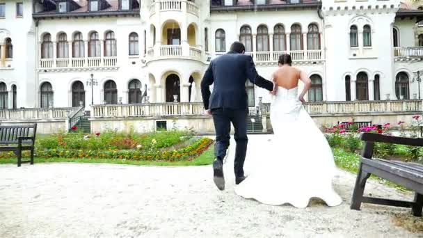 Наречений і наречений бігають під дощем перед красивим замком
 - Кадри, відео