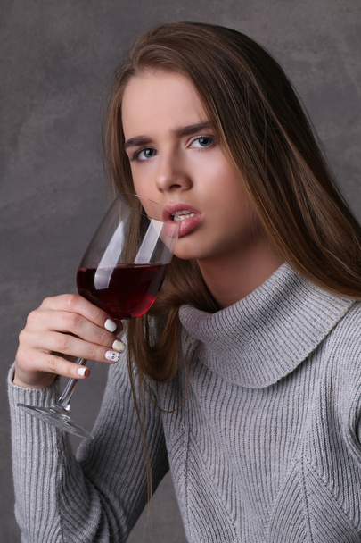 ワインを飲んでる女性クローズアップ。灰色の背景 - 写真・画像