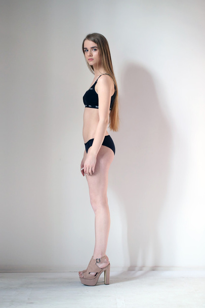 Naked girl standing profile. White background - Foto, Imagem