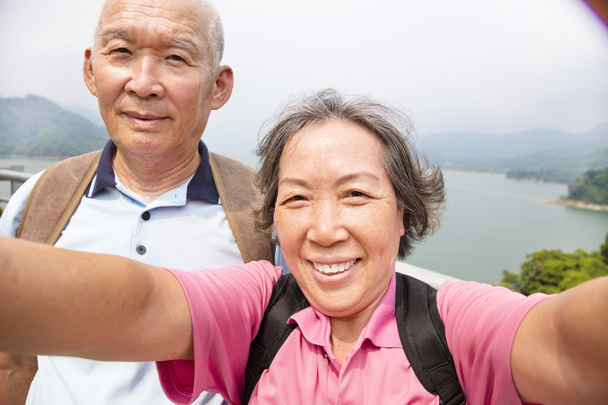 happy senior couple taking picture with smart phone selfie - Photo, Image