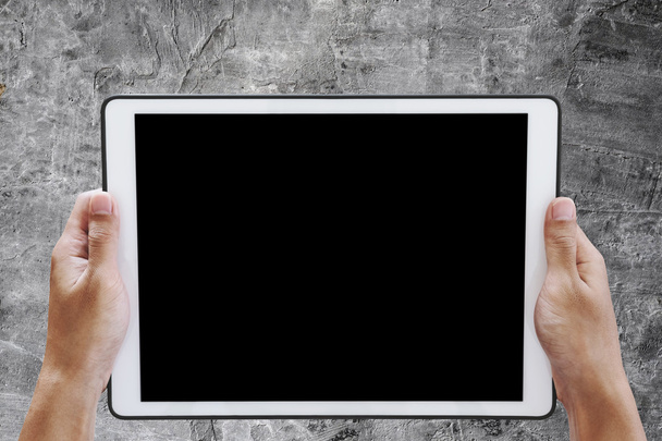 Kädestä pideltävä digitaalinen tabletti, jonka kuvaruudulla on kopiotilaa, betonisella pohjalla
 - Valokuva, kuva