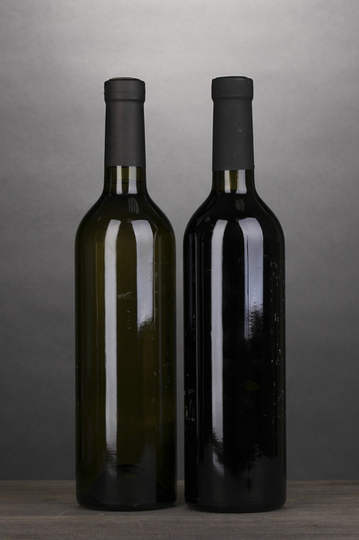 Bottles of great wine on wooden table on grey background - Photo, image