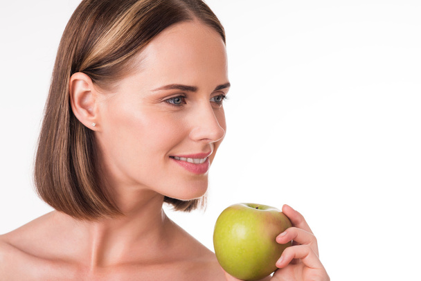 Positive young woman holding an apple - Φωτογραφία, εικόνα