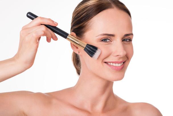 young woman using makeup brush - Foto, immagini