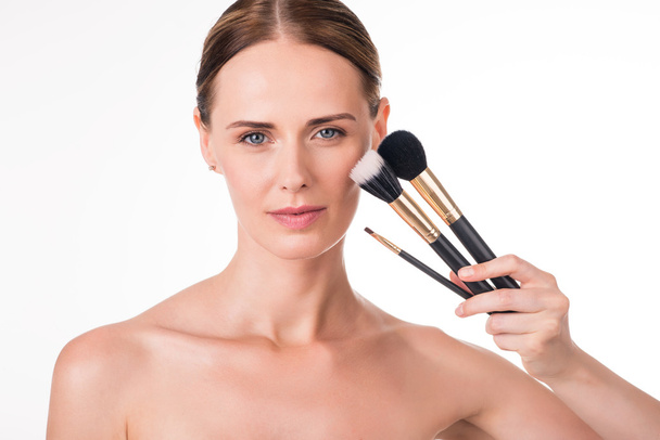 oung woman holding makeup brushes - Zdjęcie, obraz