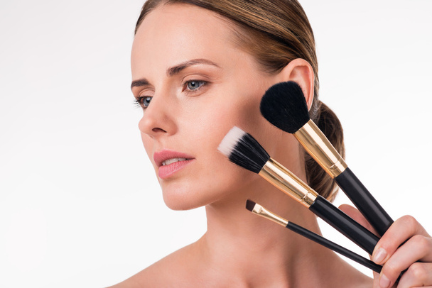 young woman holding makeup brushes - 写真・画像