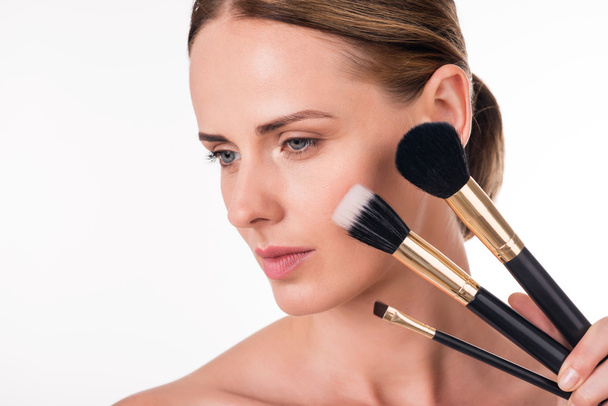 young woman holding makeup brushes - Foto, Imagen