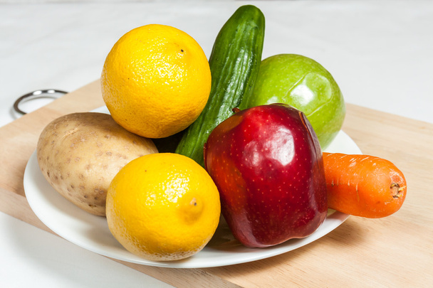 Тарелка из фруктов и овощей на доске
 - Фото, изображение