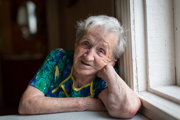 oudere vrouw aan tafel - Foto, afbeelding
