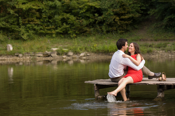 Couple of people in love sit on the bridge - Valokuva, kuva