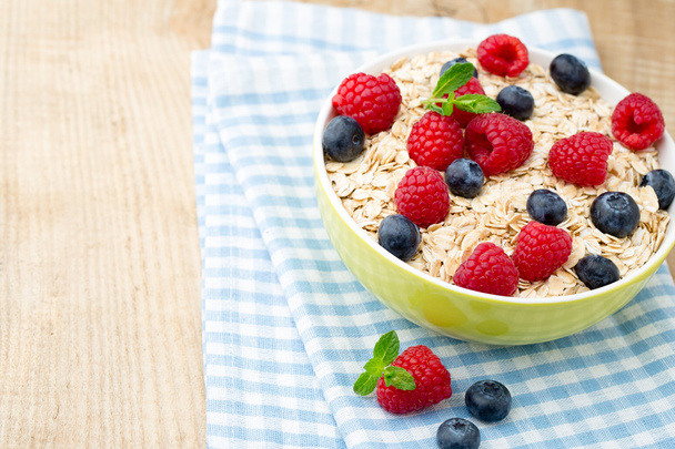 Oatmeal porridge with berries. Raspberries and blueberries. - Foto, afbeelding