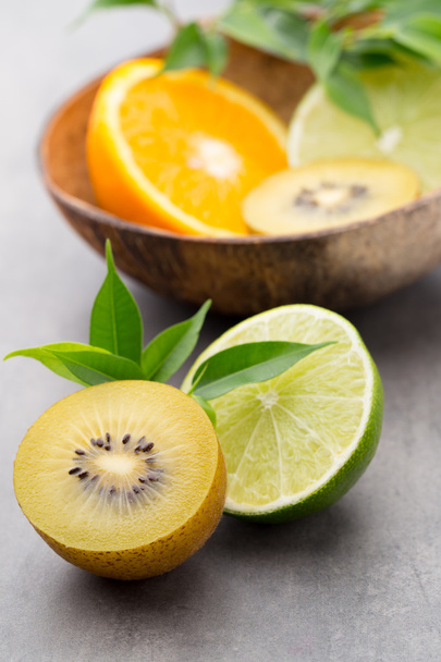 Mixed citrus fruit lemons, orange, kiwi, limes on a gray backgro - Fotoğraf, Görsel