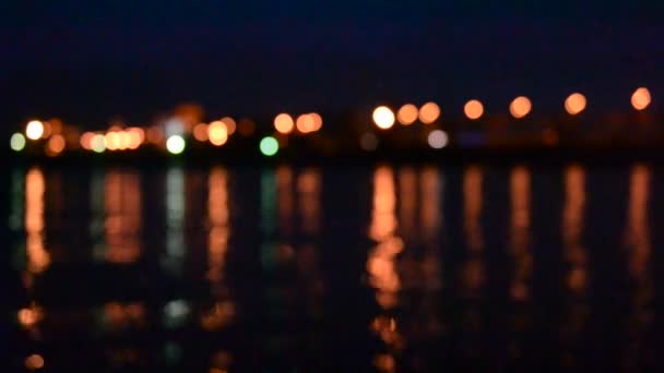 Κυκλοφορία νύχτας με αόριστες πόλη φώτα που καθρεφτίζονται στο νερό. - Πλάνα, βίντεο