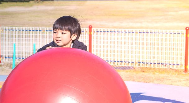 Asijské Boy hrát s velkými gumový míček v hřiště - Fotografie, Obrázek