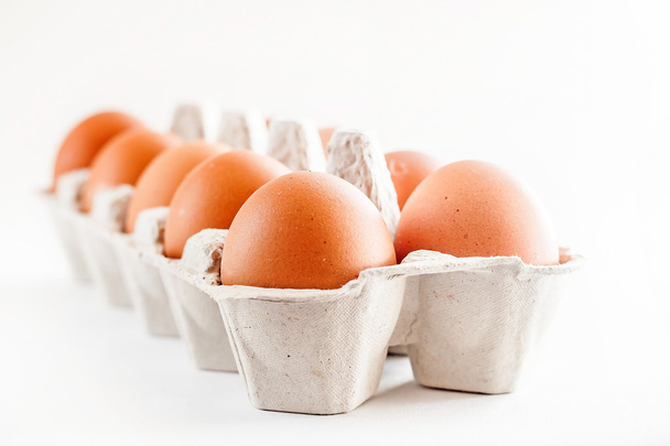 full carton of brown eggs on a white background - 写真・画像