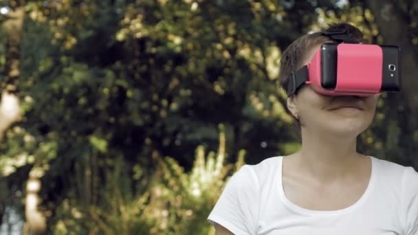 Woman explores virtual reality using VR glasses - Footage, Video