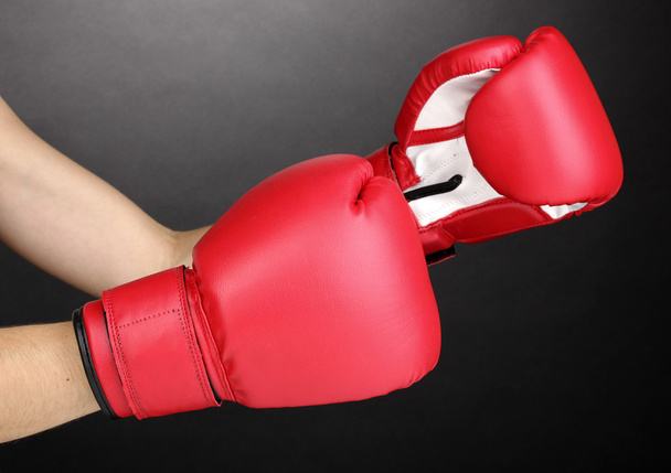 Red boxing gloves on hands on grey background - Φωτογραφία, εικόνα