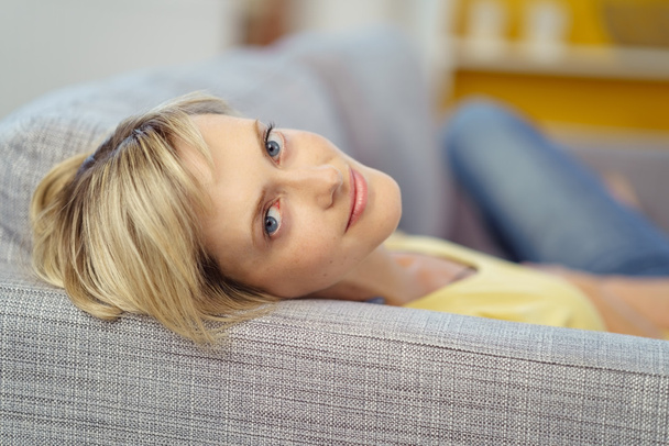 Gorgeous young woman laying down on sofa - Zdjęcie, obraz