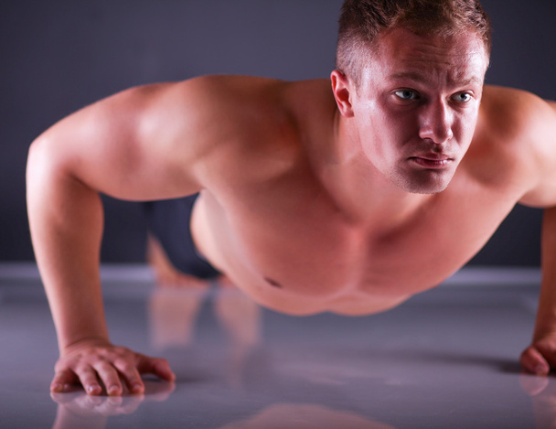 Fitness man doing push ups on floor - 写真・画像
