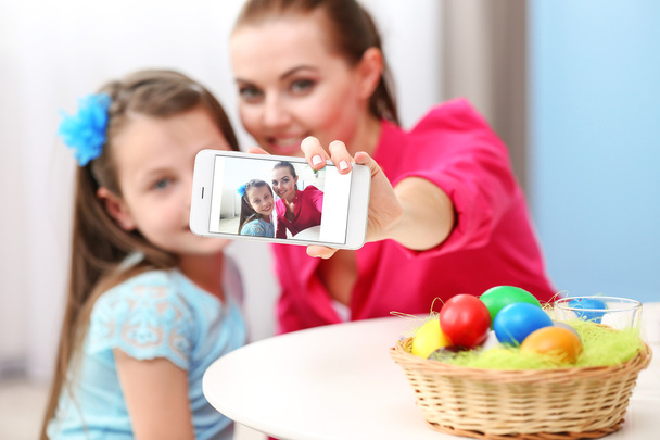 Mother and daughter taking selfie at Easter time - Foto, immagini
