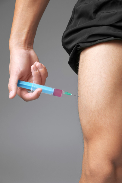 Sportsman injecting himself  - Фото, зображення