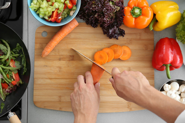 Female hands cutting carrot  - Foto, immagini