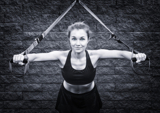 Young attractive woman does suspension training with fitness str - Valokuva, kuva