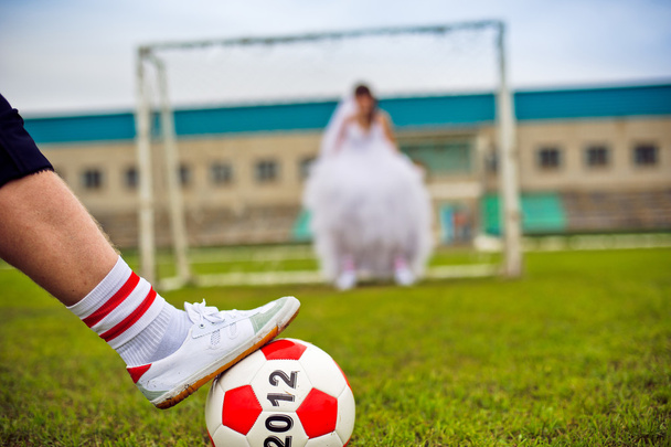 European Football Championship concept. Bride and groom on the football stadium. - 写真・画像