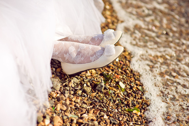 Bride's shoes on the seashore - Фото, изображение