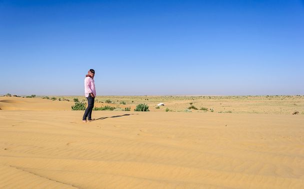 Volwassen en jonge Indiase dame toerist die zich blote voeten in het zand,  - Foto, afbeelding