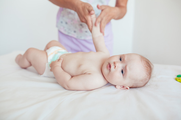 Woman doing exercises and massage the baby - Foto, afbeelding