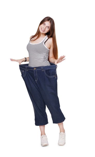 Νεαρή γυναίκα ευτυχισμένη από αποτελέσματα δίαιτα απώλειας βάρους, απομονωμένη - Φωτογραφία, εικόνα