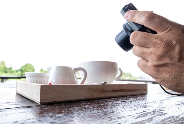 A man taking photo of coffee set.  Handholding camera shooting food shot. - Photo, Image