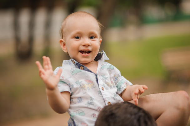 fröhlicher kleiner Sohn auf Schultern beim Papa im Sommergarten - Foto, Bild