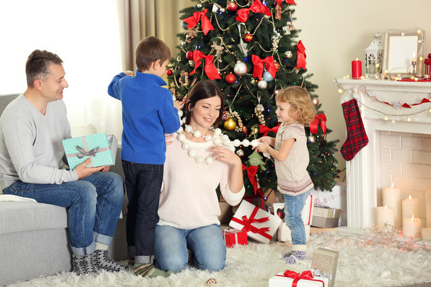 Happy family with gift boxes in home holiday living room, at morning - Zdjęcie, obraz