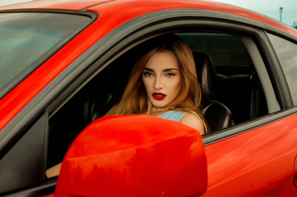 young girl driving a red car - Fotó, kép
