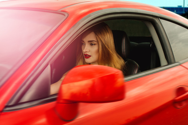 girl with red lips driving a car - Fotoğraf, Görsel