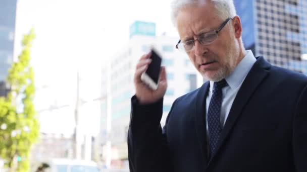 senior businessman calling on smartphone in city - Filmati, video