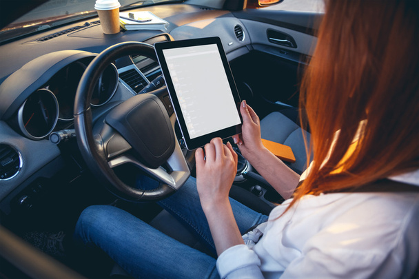 Woman in a car with a tablet in hands - Foto, imagen